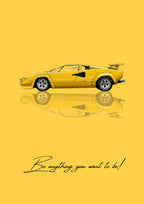 Be Anything You Want To Be – Giallo art print: a bright yellow Lamborghini Countach drawn flat in side profile, all wedge and straight edges with its rear wing up, mirrored softly below, on a warm yellow ground, with the handwritten line Be anything you want to be! along the bottom