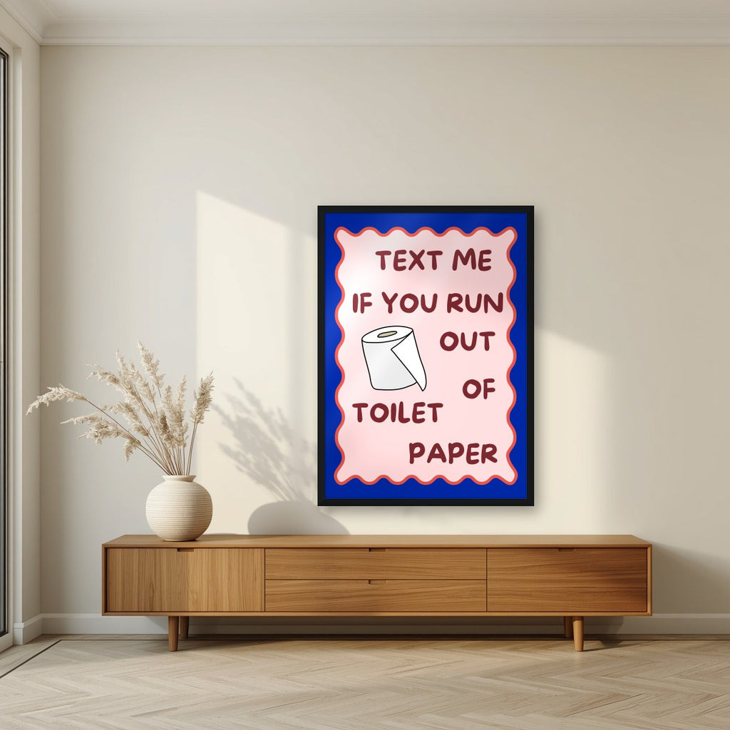 Text Me If You Run Out of Toilet Paper – Cobalt Blue art print, in a black frame, styled in a living room