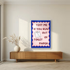 Text Me If You Run Out of Toilet Paper – Cobalt Blue art print, in a white frame, styled in a living room