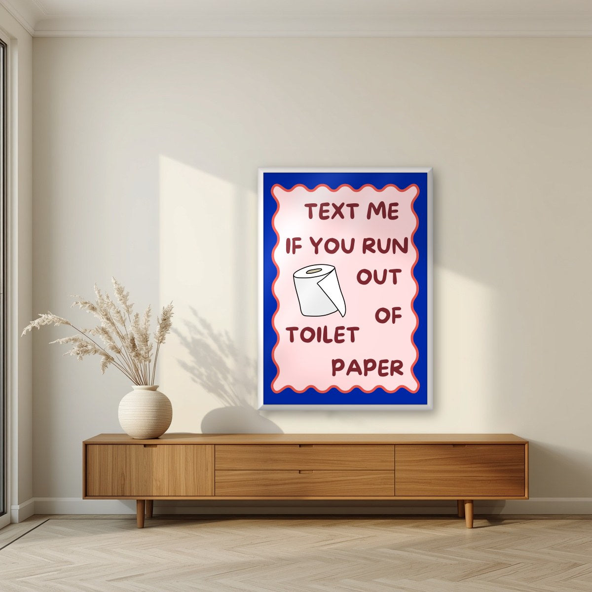 Text Me If You Run Out of Toilet Paper – Cobalt Blue art print, in a white frame, styled in a living room