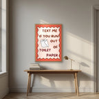 Text Me If You Run Out of Toilet Paper – Coral Clay art print, in an oak frame, styled in a desk