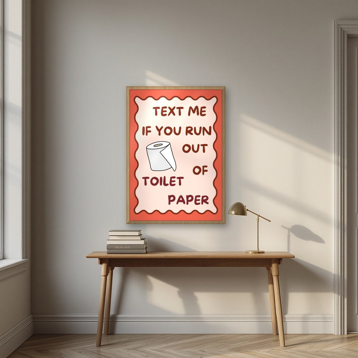Text Me If You Run Out of Toilet Paper – Coral Clay art print, in an oak frame, styled in a desk