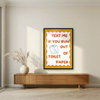 Text Me If You Run Out of Toilet Paper – Mustard Gold art print, in a black frame, styled in a living room