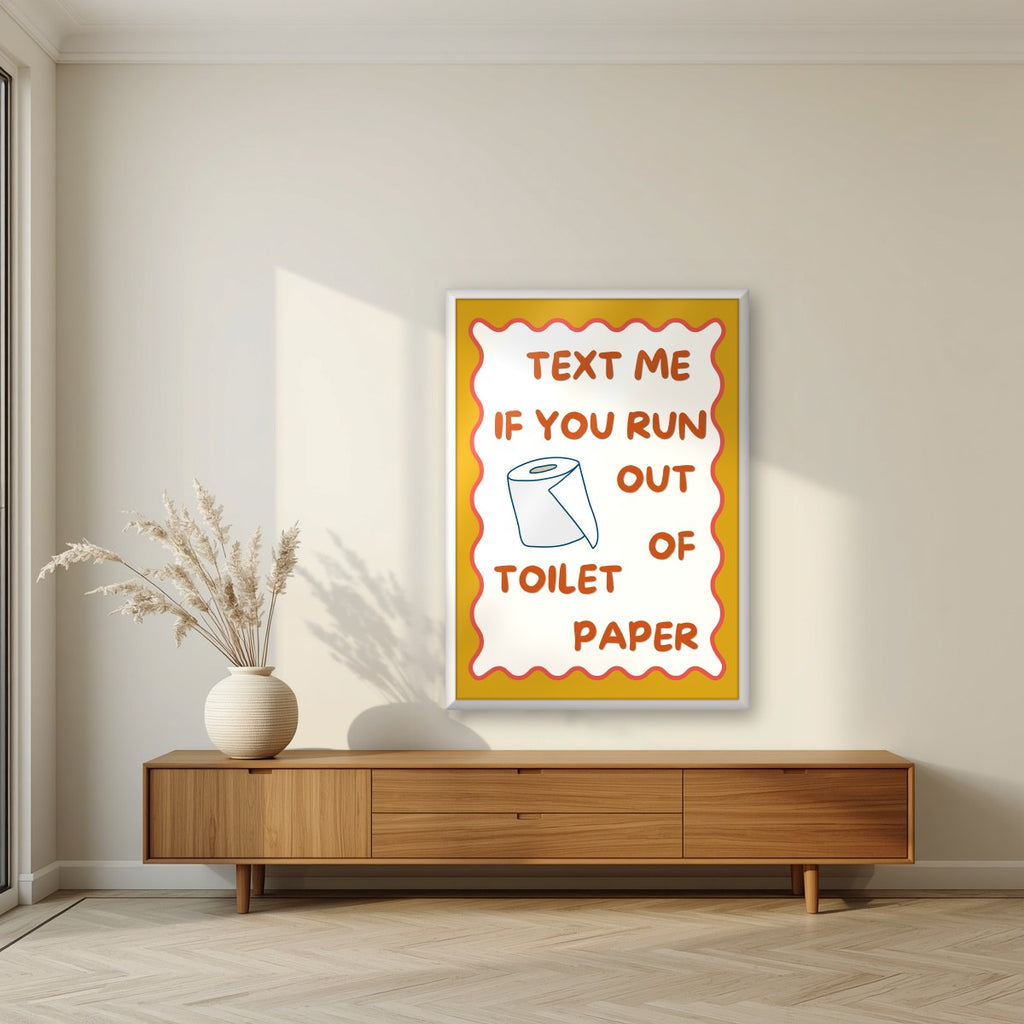 Text Me If You Run Out of Toilet Paper – Mustard Gold art print, in a white frame, styled in a living room