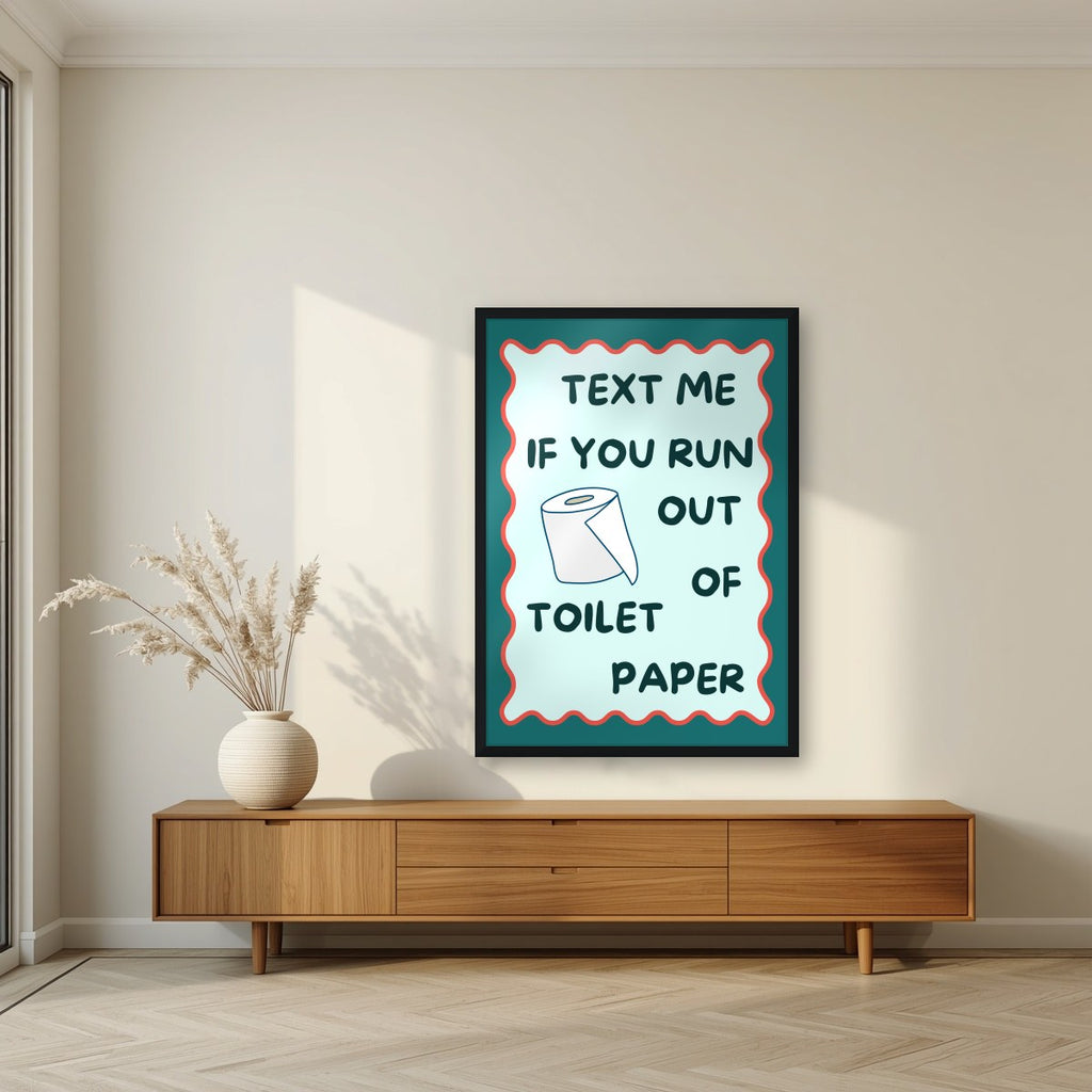 Text Me If You Run Out of Toilet Paper – Seafoam Teal art print, in a black frame, styled in a living room