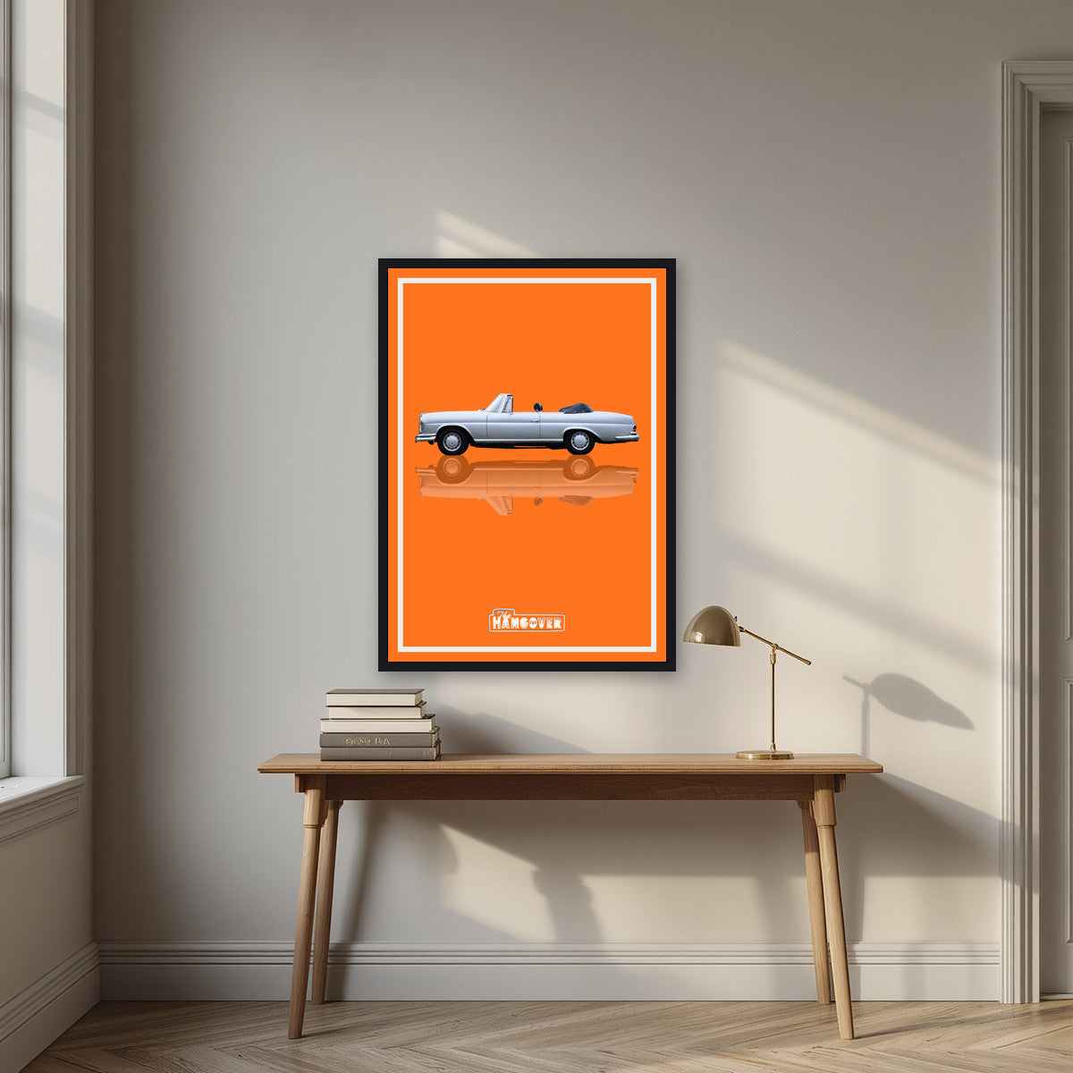 The Hangover – Desert Orange art print, in a black frame, styled in a desk