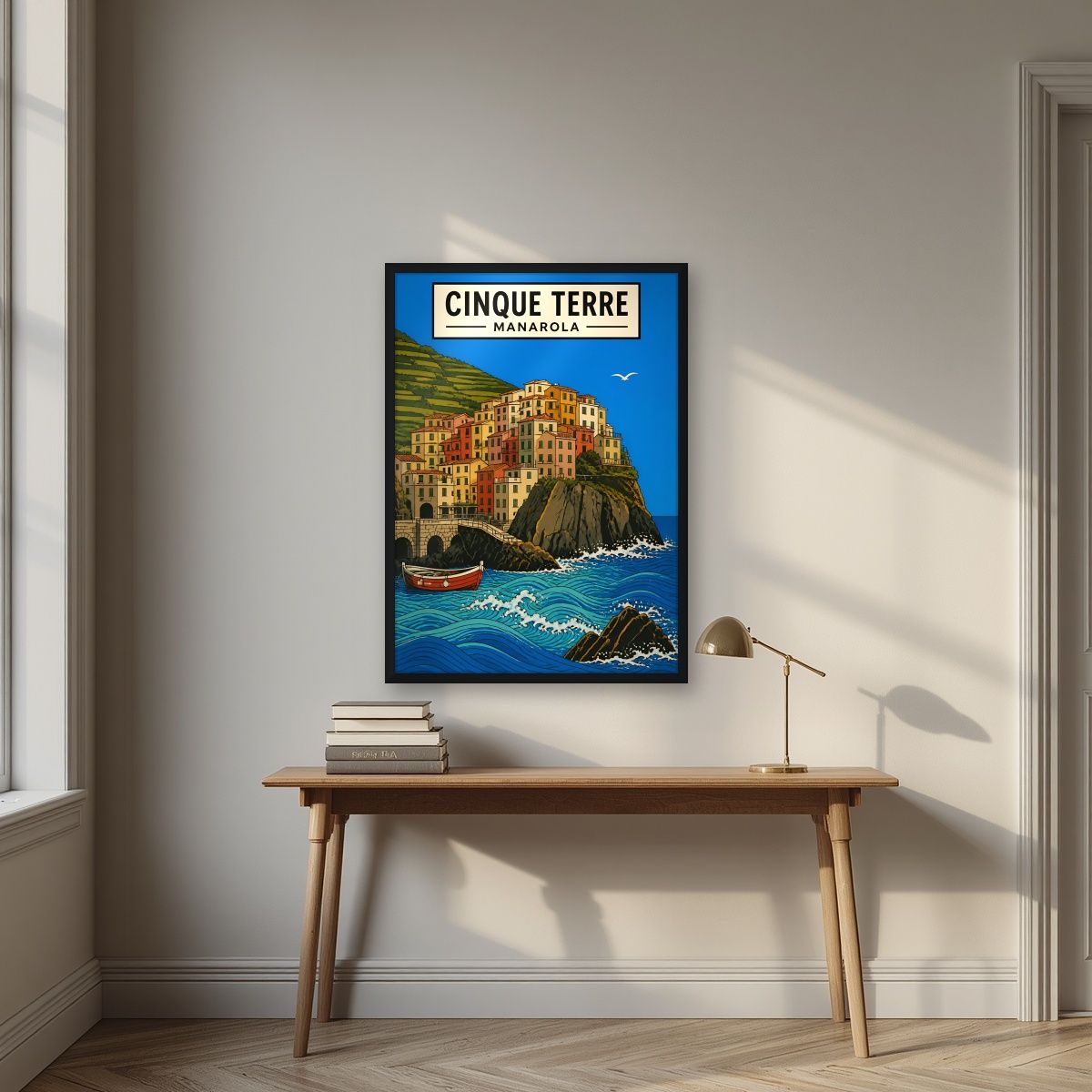 Manarola Blu — Cinque Terre art print, in a black frame, styled in a desk
