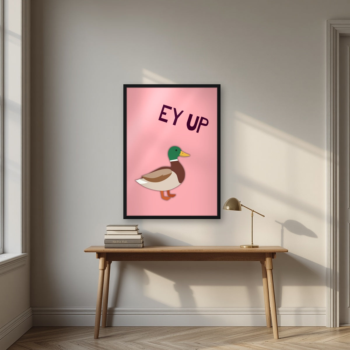 Ey Up Duck – Candyfloss Pink art print in a black frame, styled above a desk