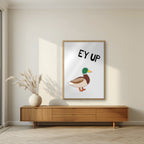 Ey Up Duck – Drizzle Grey art print in an oak frame, styled in a living room
