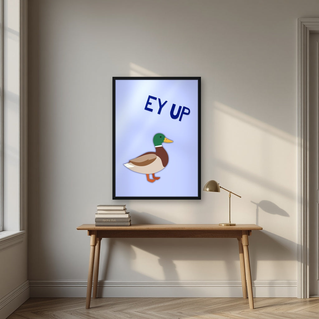 Ey Up Duck – Powder Blue art print in a black frame, styled above a desk