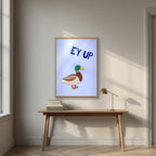 Ey Up Duck – Powder Blue art print in an oak frame, styled above a desk