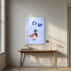 Ey Up Duck – Powder Blue art print in a white frame, styled above a desk