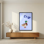 Ey Up Duck – Powder Blue art print in a black frame, styled in a living room