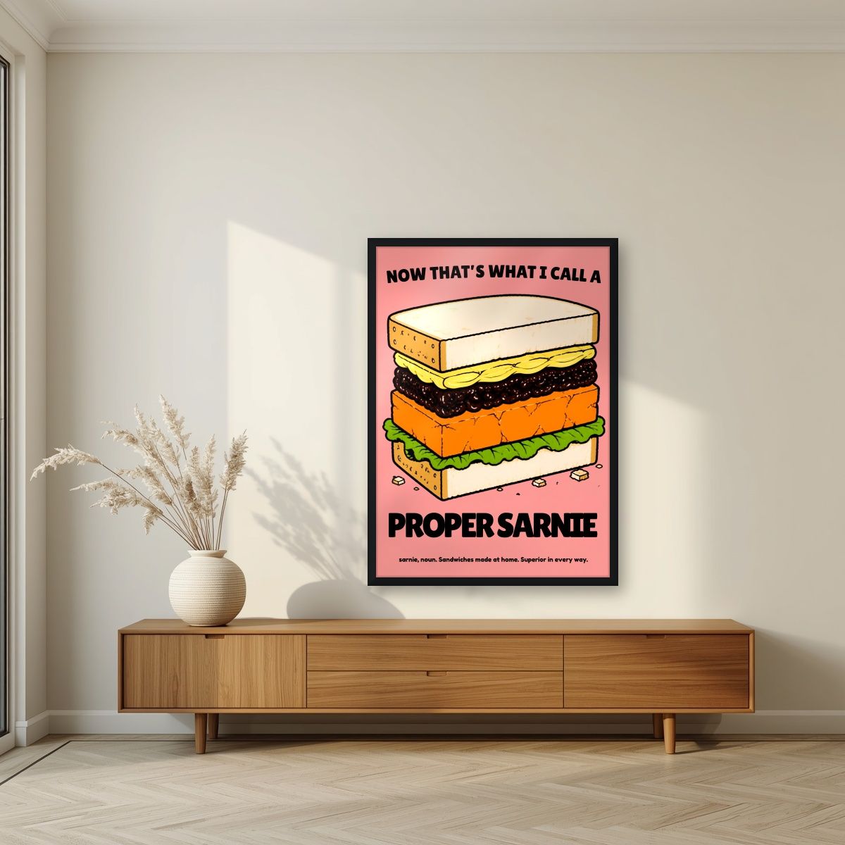 Now That's What I Call a Proper Sarnie – Battenberg Pink art print, in a black frame, styled in a living room
