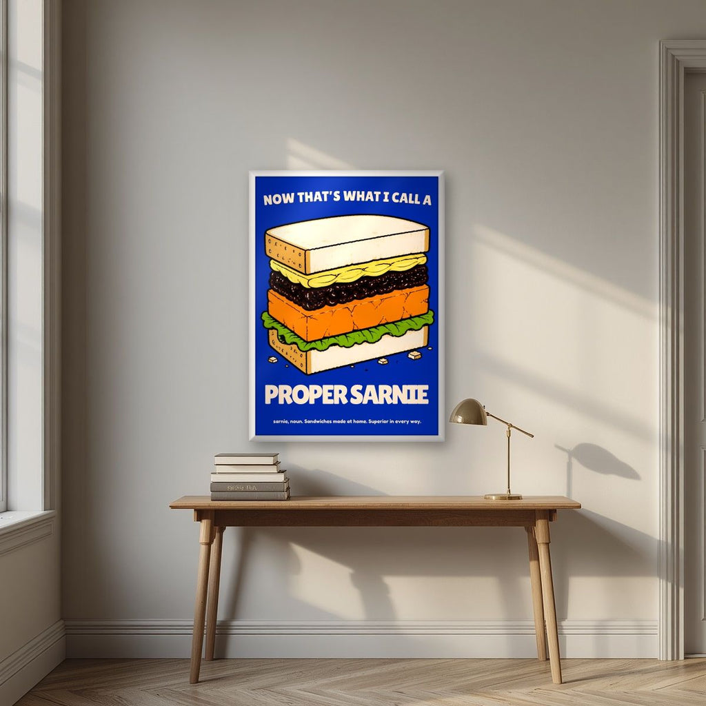 Now That's What I Call a Proper Sarnie – Deckchair Navy art print, in a white frame, styled in a desk