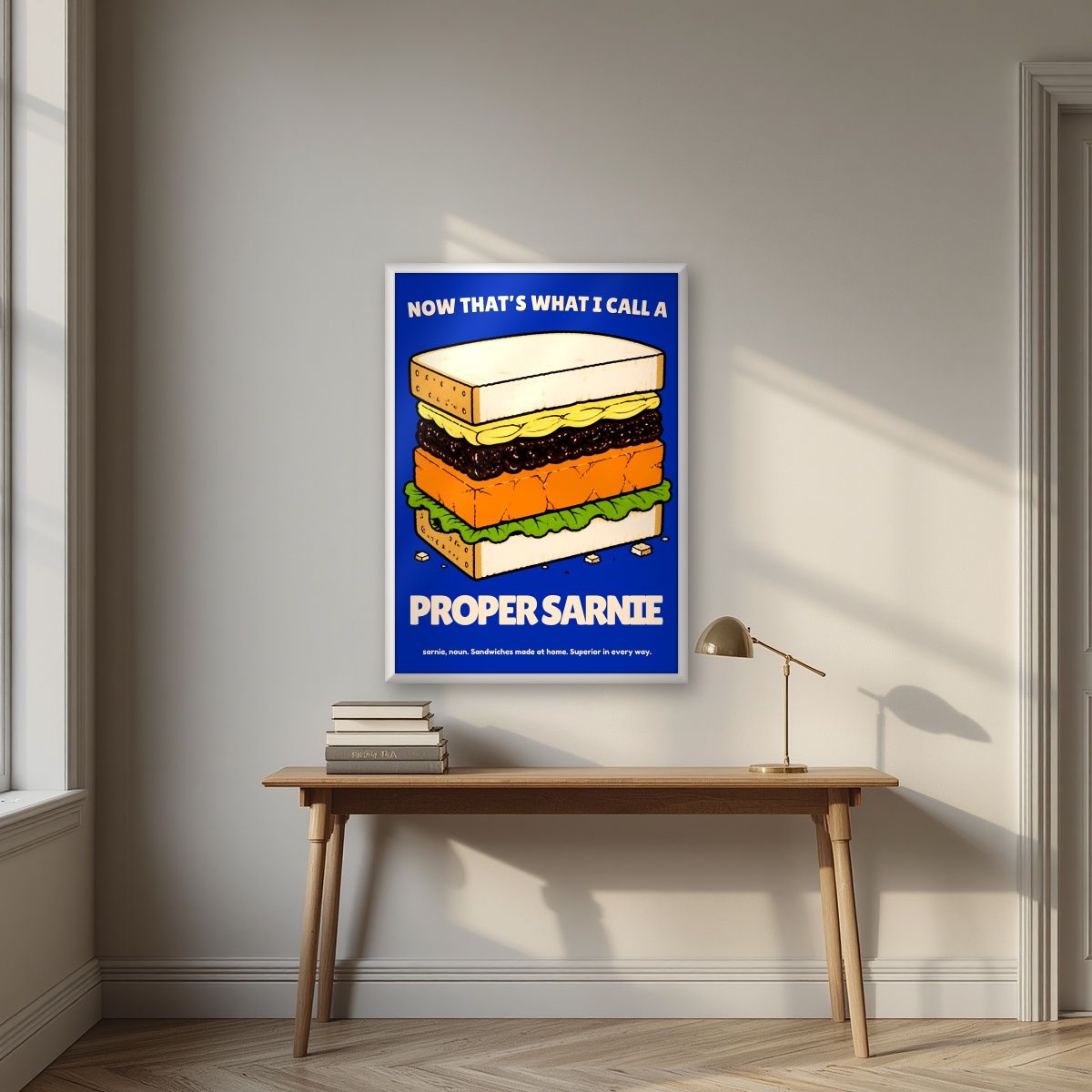 Now That's What I Call a Proper Sarnie – Deckchair Navy art print, in a white frame, styled in a desk