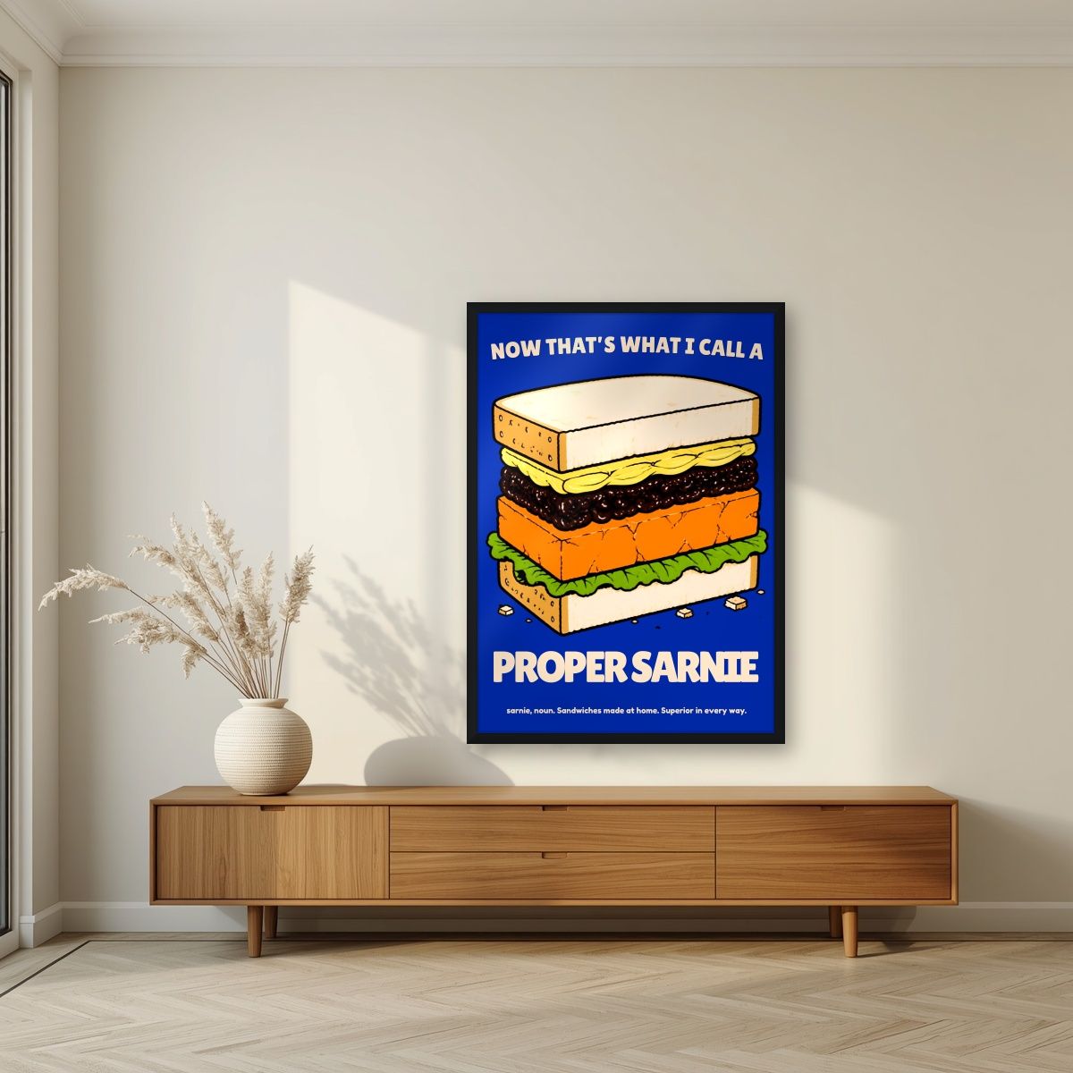 Now That's What I Call a Proper Sarnie – Deckchair Navy art print, in a black frame, styled in a living room