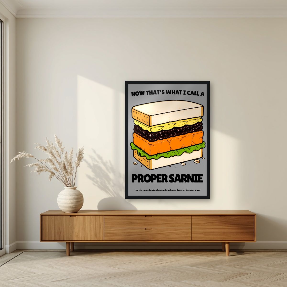 Now That's What I Call a Proper Sarnie – Drizzle Grey art print, in a black frame, styled in a living room