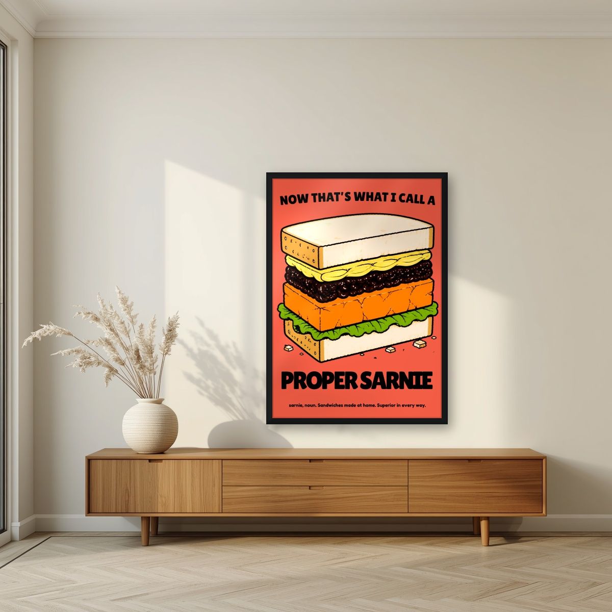 Now That's What I Call a Proper Sarnie – Ketchup Coral art print, in a black frame, styled in a living room