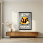 The Proof Is In The Pudding – Cobblestone Grey art print, in a black frame, styled in a living room