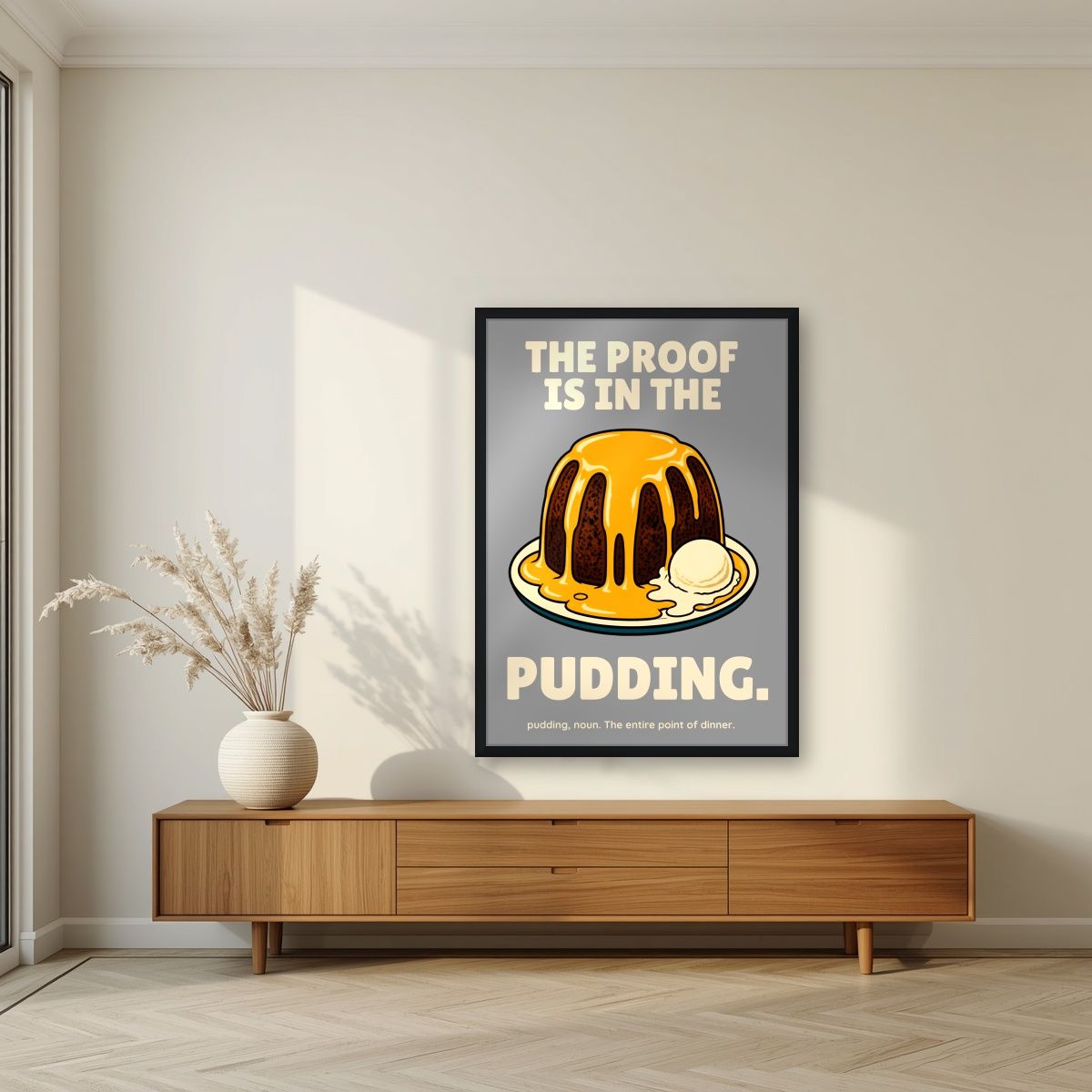 The Proof Is In The Pudding – Cobblestone Grey art print, in a black frame, styled in a living room