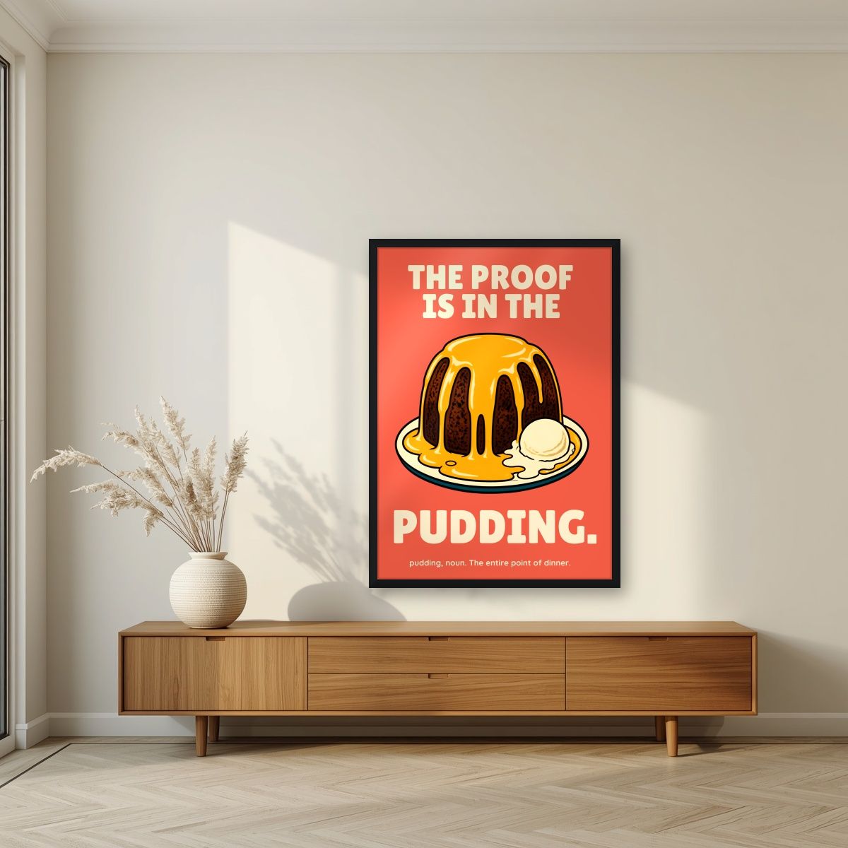 The Proof Is In The Pudding – Sunset Coral art print, in a black frame, styled in a living room