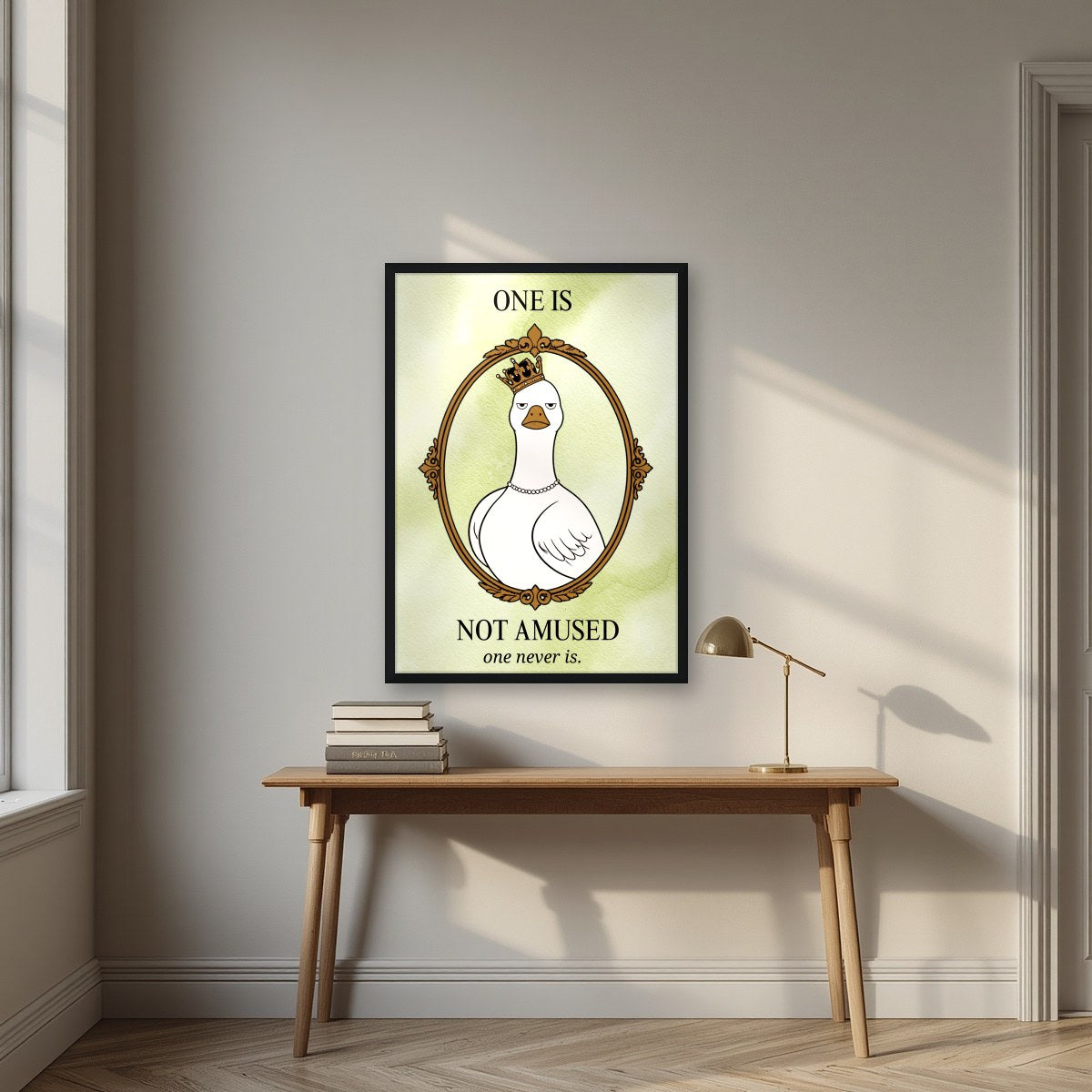 One Is Not Amused – Sage Wash art print, in a black frame, styled in a desk