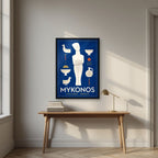 Kykladiki Morfi — Mykonos art print, in a black frame, styled in a desk