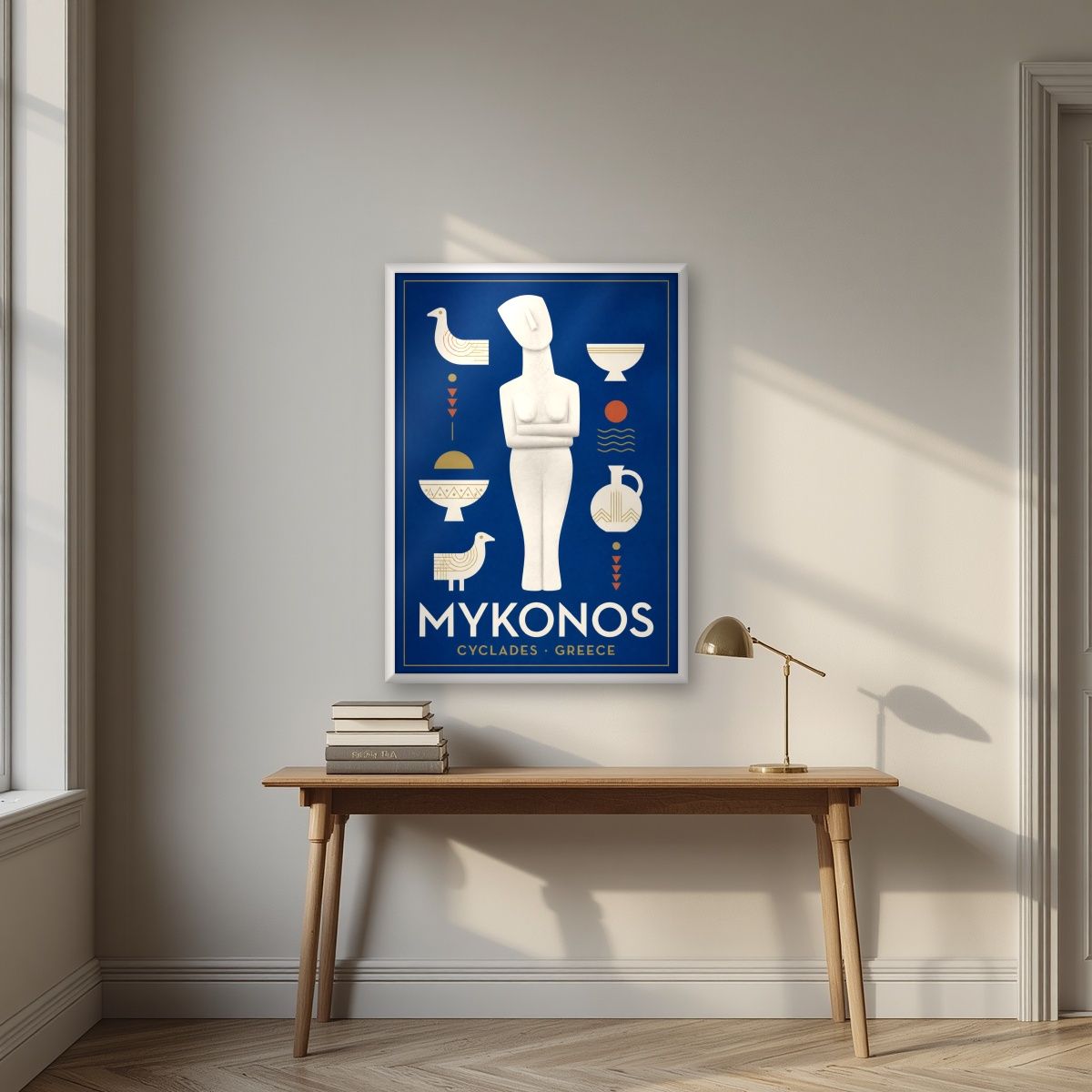 Kykladiki Morfi — Mykonos art print, in a white frame, styled in a desk