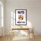 Nuts About You – Positano Pink in a black frame, above a dining table in a bright kitchen