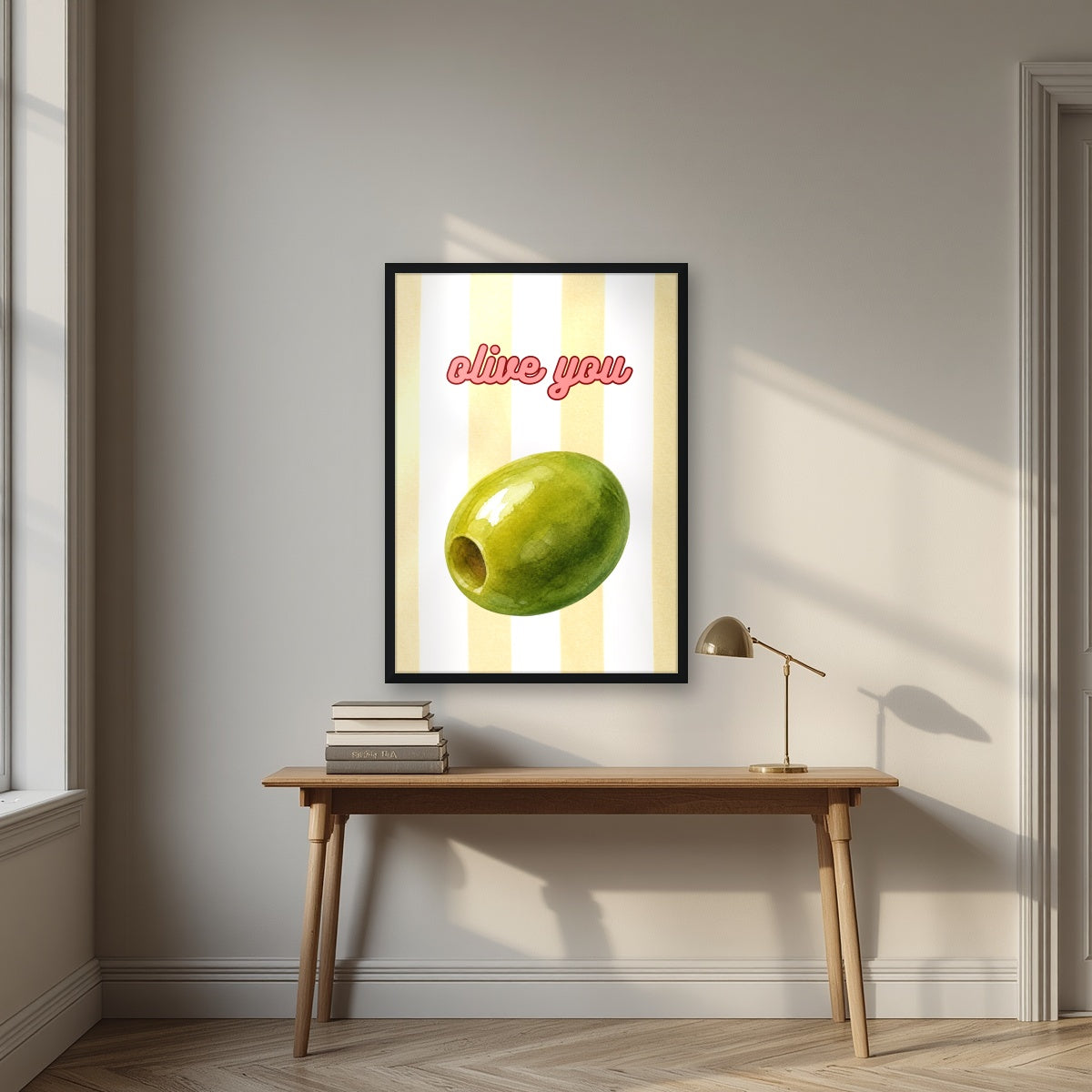 Olive You – Limoncello in a black frame, above an oak writing desk