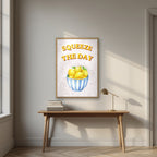 Squeeze The Day – Tuscan Taupe in an oak frame, above an oak writing desk