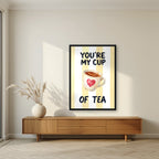 You're My Cup of Tea – Limoncello in a black frame, above a walnut sideboard in a living room