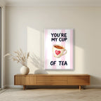 You're My Cup of Tea – Positano Pink in a white frame, above a walnut sideboard in a living room