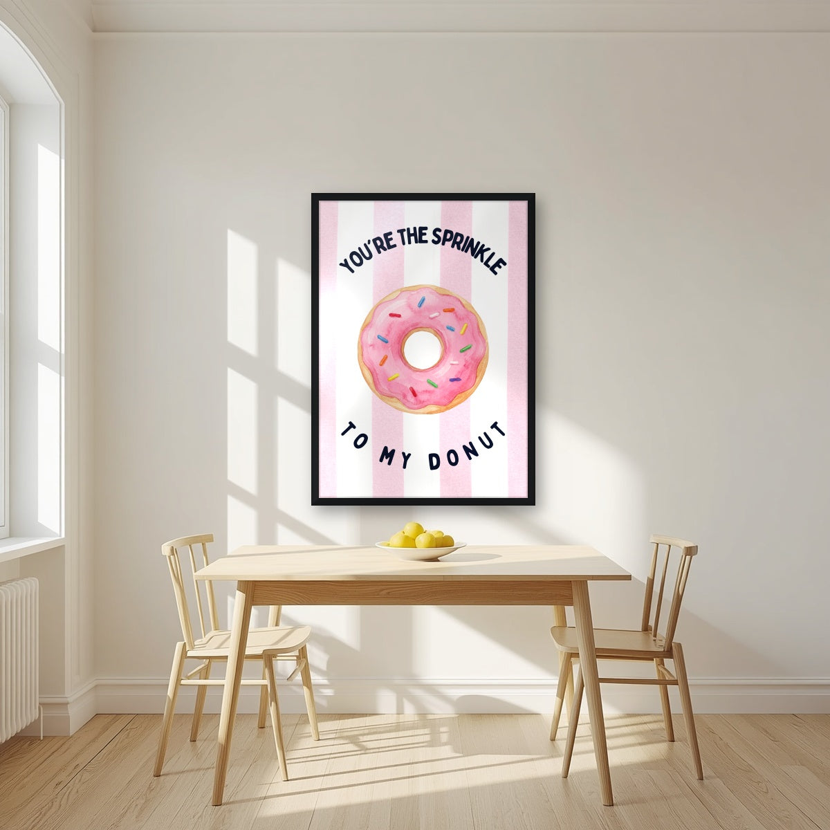 You're the Sprinkle to My Donut – Positano Pink in a black frame, above a dining table in a bright kitchen